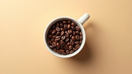 A top down view of a white cup filled with coffee beans on a beige background with a handle on the side
