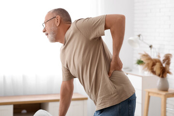 Mature man suffering from back pain at home