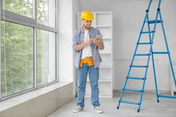 Male contractor working with tablet computer in room