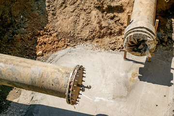 New plastic water pipeline in trench. Replacement of old rusty tubes by new one
