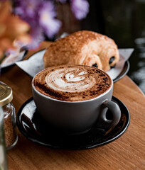 Morning Bliss in a Cup. A cozy cup of cappuccino with perfect latte art, paired with a flaky chocolate croissant — the ultimate café moment.