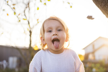 little preschool happy kid child sticking out tongue. Selective focus. nature.