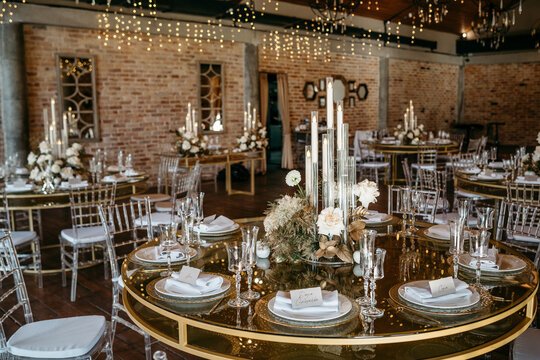 Elegant wedding reception setup with candlelit tables and floral centerpieces in rustic venue