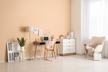 Interior of fashion designer's office with workplace, lamp and armchair