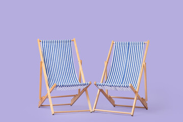 Striped deck chairs on lilac background