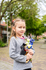Photo of happy smiling girl child kid school pupil spending time summer holiday having fun meeting hanging out outside in green nature park looking at camera