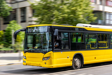 Yellow city bus. Public transport in motion. Street speed blur