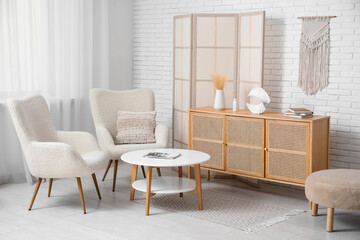 Interior of modern room with folding screen, armchairs and table