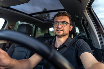 Man driving car. Positive emotions. Bright daylight interior.