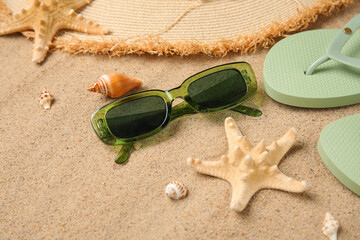 Summer composition with seashells, starfish and beach accessories on sand as background, closeup