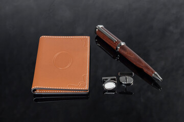 Branded pen with cufflinks and business card holder in a box. Gift set. Office interior.