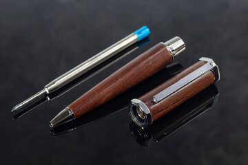 Branded pen with cufflinks and business card holder in a box. Gift set. Office interior.