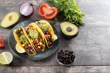 Vegetarian Taco with beans and guacamole on wooden table. Copy space