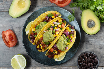 Vegetarian Taco with beans and guacamole on wooden table. Top view