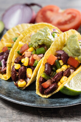 Vegetarian Taco with beans and guacamole on wooden table