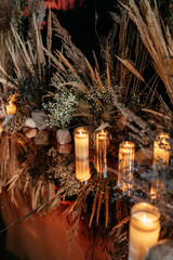Candlelit table with dried flowers and grasses in elegant rustic setting