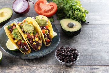 Vegetarian Taco with beans and guacamole on wooden table. Copy space