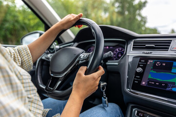 Naklejka premium Female driver at car wheel. Navigation display. Modern vehicle interior