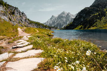 Stunning alpine lake surrounded by lush greenery and dramatic mountain peaks in Austria. Perfect harmony of nature, captured in breathtaking light – ideal for travel, tourism, and nature visuals.
