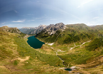 Stunning alpine lake surrounded by lush greenery and dramatic mountain peaks in Austria. Perfect...