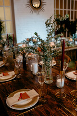 Elegant rustic dinner setting with eucalyptus decor and candles in a cozy ambiance