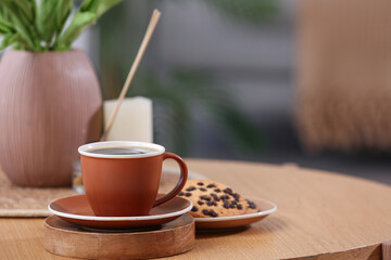 Cup of hot coffee and plate with tasty cookies on wooden table in room