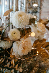 Elegant white floral arrangement with delicate lights and golden foliage