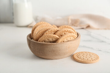 Wooden bowl with sweet cookies on white background