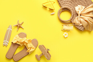 Summer composition with beach accessories on yellow background