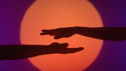 Silhouette of Hands in Artistic Orange and Purple Light