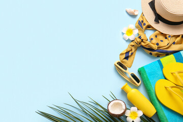 Summer composition with coconut, flowers and beach accessories on blue background