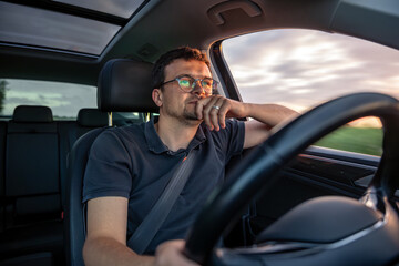 Thoughtful driver. Sunset road. Blurred window motion