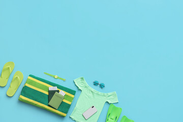 Composition with passports, mobile phone and beach accessories on blue background