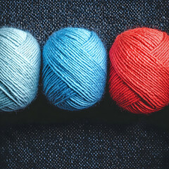 Colorful yarn balls on dark fabric background, craft supplies, hobby, DIY project