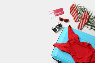 Composition with suitcase, swimsuit, photo camera and beach accessories isolated on white background
