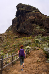 Naklejka premium Tourist hiking rugged volcanic trail