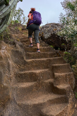 Hiker ascending volcanic trail in Anaga