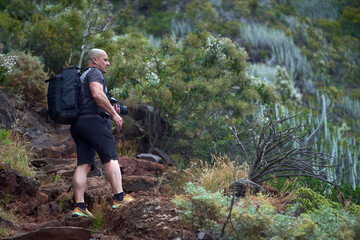 Man with camera on volcanic trail