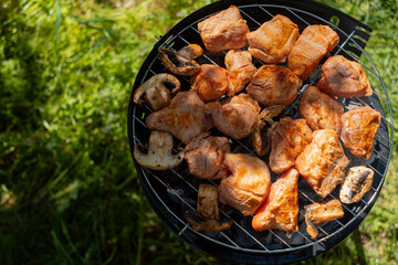 Close up of meat on grill rack browning over open fire for a tasty barbecue cooking experience outdoors.