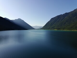 Panoramic Landscape of a Vast Lake with Majestic Mountain Backdrop