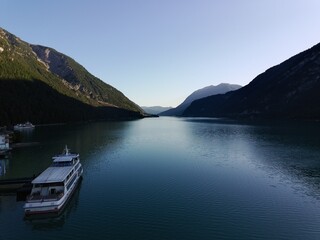 Panoramic View of a Vast Mountain Lake with a Ship Docked at the Pier