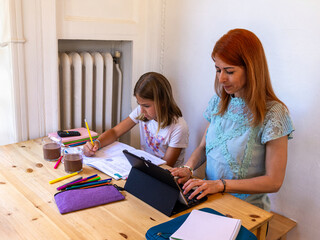 Mother and daughter doing homework together at home