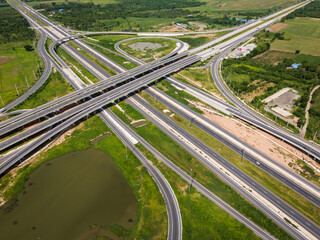 Drone shot a large highway interchange crossing over green farmlands in Thailand