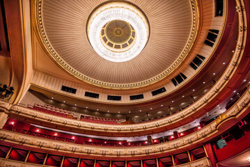 Opera house ceiling with grand chandelier and balconies
