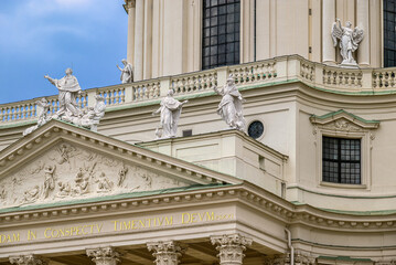 Close-up of Karlskirche facade with statues and Latin inscription
