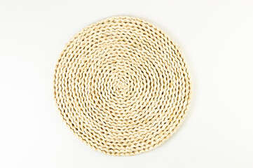 Top view of brown wicker table mat on white background. Straw round tray, flat lay, copy space. 
