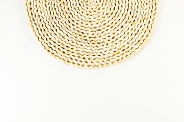 Top view of brown wicker table mat on white background. Straw round tray, flat lay, copy space. 