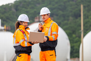 Engineers Collaborating at Industrial Site with Storage Tanks, Team of Engineer Conducting Operations at Oil Storage Field Industrial Site, Industrial Engineers Observing Oil Refinery and Using Laptop