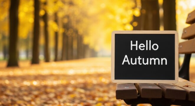 Blackboard with hello autumn text on wooden park bench. Seasonal greeting concept for fall holiday. Warm inviting backdrop for copy space.