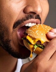 biting into a juicy burger, with melted cheese and sauce dripping for a mouthwatering effect. Ideal for fast food, indulgence, or modern dining imagery.